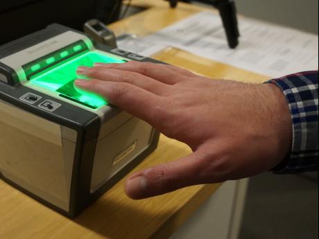 Hand over machine that scans fingerprints for security investigation.
